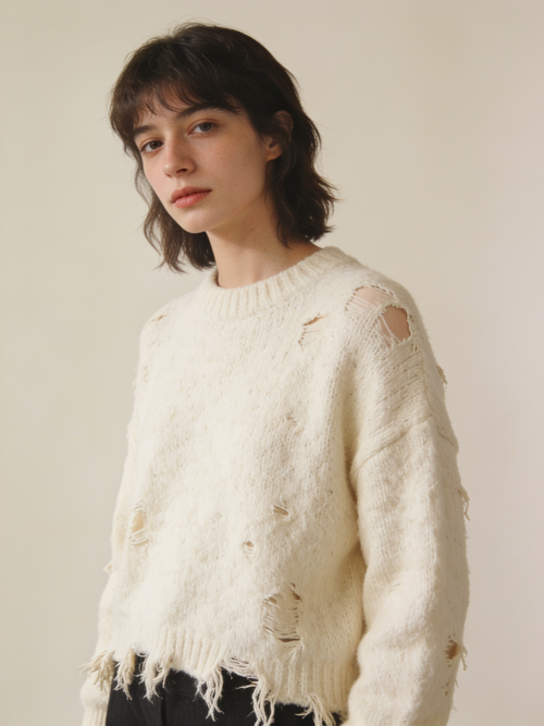 Model wearing the distressed wool knit in ecru