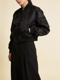 Model wearing the cropped nylon bomber in black